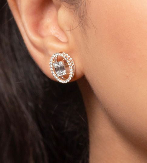 Close-up of a woman wearing a rose gold necklace with a pendant against a black background