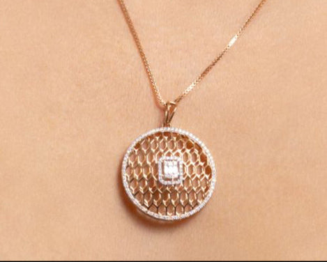 Rose gold necklace with a circular pendant on a person's neck